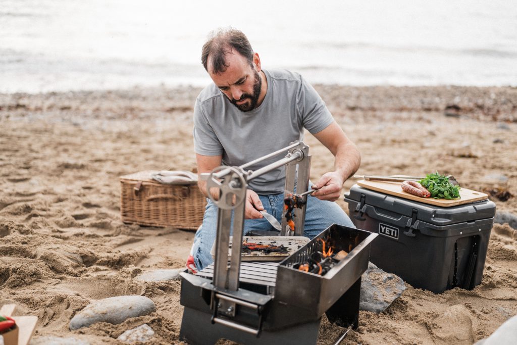 Somerset Grill company photo of Man on a beach with a grill