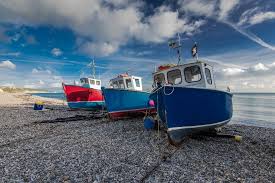 Photo of fishing boats on a gravel beach
