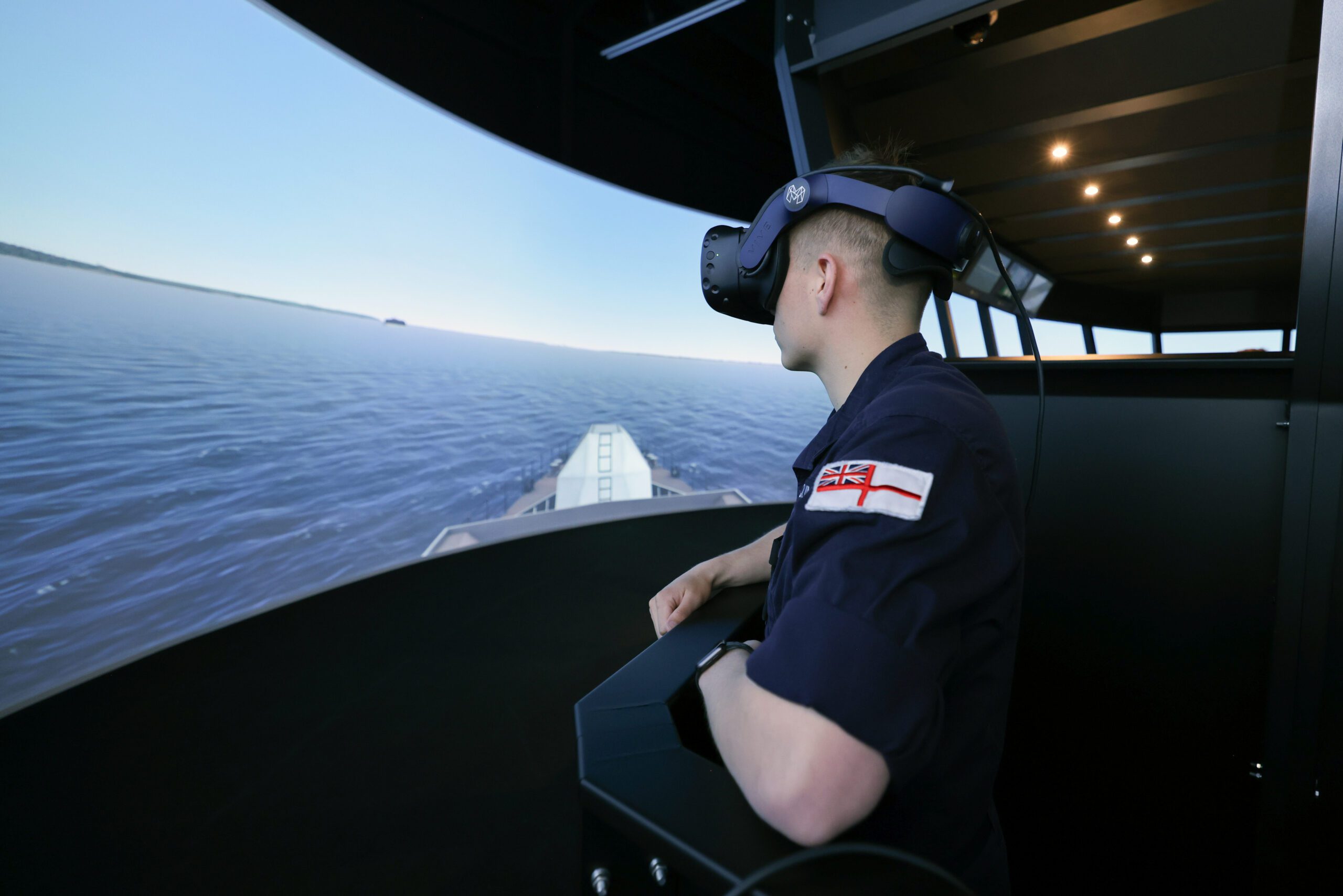 Photo of sailor with virtual reality headset looking out to see